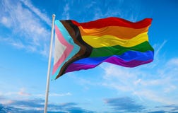 Progress LGBTQ rainbow flag waving in the wind at cloudy sky. Freedom and love concept. Pride month. activism, community and