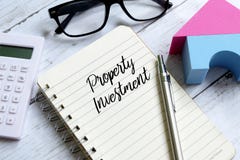 Property investment written on a notebook. Business and finance concept