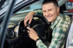 Proprietario felice del veicolo che tiene le sue mani sul volante fotografia stock libera da diritti Proprietario felice del veicolo che tiene le sue mani sul volante fotografia stock libera da diritti