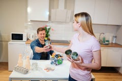 Protegga l'ambiente Giovane uomo sorridente che dà alla sua amica i barattoli di latta del metallo mentre lui che ordina lo sprec fotografia stock libera da diritti Protegga l'ambiente Giovane uomo sorridente che dà alla sua amica i barattoli di latta del metallo mentre lui che ordina lo sprec fotografia stock libera da diritti