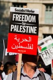 Protesteerder met aanplakbiljet in Gaza: Houd de Slachtingsverzameling in Whitehall, Londen, het UK tegen royalty-vrije stock fotografie Protesteerder met aanplakbiljet in Gaza: Houd de Slachtingsverzameling in Whitehall, Londen, het UK tegen royalty-vrije stock fotografie