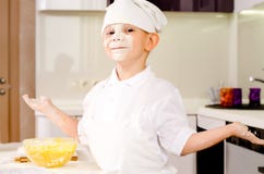 proud playful little boy chefs uniform baking kitchen shrugging his hands as gets his face covered flour adding 42273424
