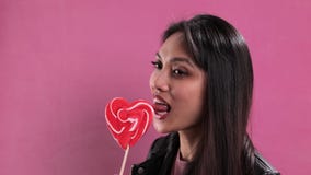 Prtetty woman licks on a giant lollipop
