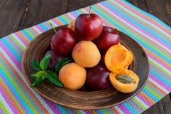 Prunes mûres (variété : La reine-claude) et les abricots dans un argile roulent sur un fond lumineux photos stock Prunes mûres (variété : La reine-claude) et les abricots dans un argile roulent sur un fond lumineux photos stock