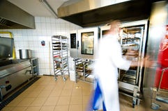 Przemysłowy kuchenny wnętrze z ruchliwie kucharzami obrazy stock Przemysłowy kuchenny wnętrze z ruchliwie kucharzami obrazy stock
