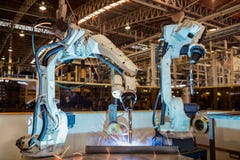 Przemysłowy robot jest spawalniczego zgromadzenie stalowym częścią w samochodowej fabryce obrazy stock Przemysłowy robot jest spawalniczego zgromadzenie stalowym częścią w samochodowej fabryce obrazy stock