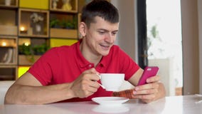 przestań tła rogalik filiżanki kawy sweet Mężczyzna używa telefon komórkowego podczas gdy pijący kawę zbiory wideo przestań tła rogalik filiżanki kawy sweet Mężczyzna używa telefon komórkowego podczas gdy pijący kawę zbiory wideo