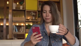przestań tła rogalik filiżanki kawy sweet Żeński używa telefon komórkowy podczas gdy pijący kawę zbiory wideo przestań tła rogalik filiżanki kawy sweet Żeński używa telefon komórkowy podczas gdy pijący kawę zbiory wideo