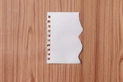 Prześcieradło notatnika papier z poszarpanym krawędzi pustym miejscem rozdzierał kawałek na odosobnionym nadmiernym drewnianym st obrazy stock Prześcieradło notatnika papier z poszarpanym krawędzi pustym miejscem rozdzierał kawałek na odosobnionym nadmiernym drewnianym st obrazy stock