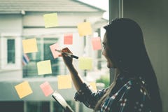 Przypadkowy kreatywnie biznesowej kobiety writing ideał dalej i cel okno Obraz Stock Przypadkowy kreatywnie biznesowej kobiety writing ideał dalej i cel okno Obraz Stock
