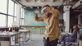 Przystojny młody biznesmen robi zwycięstwo tanu o pomyślnym osiągnięciu Szczęśliwa samiec przy nowożytnym modnym biurem zbiory Przystojny młody biznesmen robi zwycięstwo tanu o pomyślnym osiągnięciu Szczęśliwa samiec przy nowożytnym modnym biurem zbiory