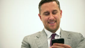 Przystojny młody biznesowy mężczyzna używa smartphone uśmiecha się szczęśliwą jest ubranym kostium kurtkę biznesmena smartphone u zbiory Przystojny młody biznesowy mężczyzna używa smartphone uśmiecha się szczęśliwą jest ubranym kostium kurtkę biznesmena smartphone u zbiory