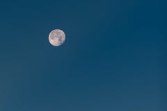 Près de la pleine lune avec les cratères évidents en ciel bleu d'hiver photos libres de droits Près de la pleine lune avec les cratères évidents en ciel bleu d'hiver photos libres de droits