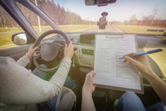 Prüfer, der Fahrer ` s Lizenzstraßenversuchform ausfüllt Stockbild Prüfer, der Fahrer ` s Lizenzstraßenversuchform ausfüllt Stockbild