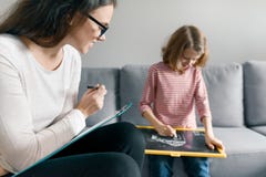 Psicólogo fêmea novo que fala com a menina paciente da criança no escritório Saúde mental das crianças fotografia de stock royalty free Psicólogo fêmea novo que fala com a menina paciente da criança no escritório Saúde mental das crianças fotografia de stock royalty free