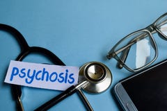 Psychosis inscription with the view of stethoscope, eyeglasses and smartphone on the blue background. royalty free stock photography Psychosis inscription with the view of stethoscope, eyeglasses and smartphone on the blue background. royalty free stock photography