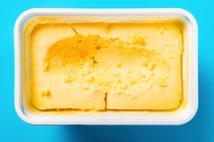 Pudełko mangowy smaku lody z niektóre digged za błękitnym tle na fotografia royalty free Pudełko mangowy smaku lody z niektóre digged za błękitnym tle na fotografia royalty free