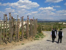 Pueblo Uchisar Muestra del valle de la paloma Tres hombres en trajes negros y camisas blancas están caminando a lo largo del cami fotografía de archivo libre de regalías Pueblo Uchisar Muestra del valle de la paloma Tres hombres en trajes negros y camisas blancas están caminando a lo largo del cami fotografía de archivo libre de regalías