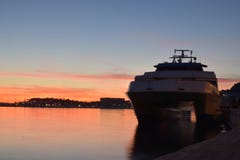 Puesta del sol con el barco que espera para entregar passangers Imagenes de archivo Puesta del sol con el barco que espera para entregar passangers Imagenes de archivo