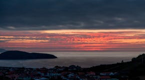 Puesta del sol hermosa sobre la ciudad por el mar fotos de archivo libres de regalías Puesta del sol hermosa sobre la ciudad por el mar fotos de archivo libres de regalías