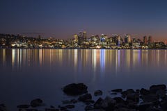 Puesta del sol sobre el horizonte del ` s de Seattle que crea reflexiones en el lago Washington imagen de archivo Puesta del sol sobre el horizonte del ` s de Seattle que crea reflexiones en el lago Washington imagen de archivo