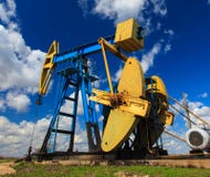 Puits fonctionnant de pétrole et de gaz profilé sur le ciel ensoleillé image libre de droits Puits fonctionnant de pétrole et de gaz profilé sur le ciel ensoleillé image libre de droits