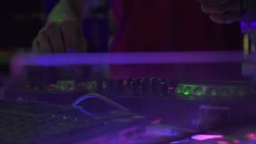 Puleggia tenditrice di disco maschio della mano sulla piattaforma del DJ per musica mescolantesi della casa sul partito di discot video d archivio Puleggia tenditrice di disco maschio della mano sulla piattaforma del DJ per musica mescolantesi della casa sul partito di discot video d archivio