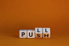 Pull or push symbol. Turned wooden cubes and changed the word `push` to `pull`. Beautiful orange background, copy space. Busin