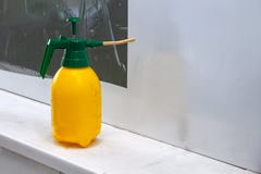 Pulverizador industrial amarelo com uma tampa verde para a água de pulverização na oficina para colar o filme em um fundo branco foto de stock royalty free Pulverizador industrial amarelo com uma tampa verde para a água de pulverização na oficina para colar o filme em um fundo branco foto de stock royalty free