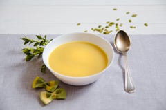 Pumpkin cream soup with pumpkin seeds in white plates with a silver spoon stock photo Pumpkin cream soup with pumpkin seeds in white plates with a silver spoon stock photo