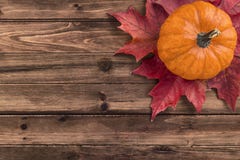 Pumpkin with red maple leafs disposed on wooden table. stock photography Pumpkin with red maple leafs disposed on wooden table. stock photography