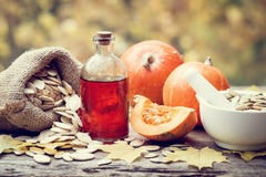 Pumpkin seeds oil bottle, pumpkins, bag with seeds and mortar Royalty Free Stock Photography Pumpkin seeds oil bottle, pumpkins, bag with seeds and mortar Royalty Free Stock Photography
