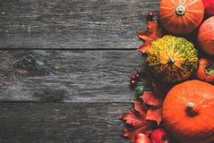 Pumpkins and maple leaves on wooden background. Fall frame Stock Photo Pumpkins and maple leaves on wooden background. Fall frame Stock Photo