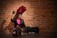 Punkrockflicka på bakgrund för tegelstenvägg Royaltyfri Bild Punkrockflicka på bakgrund för tegelstenvägg Royaltyfri Bild