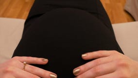 Punkt widzenia muska jej brzuszek kobieta w ciąży podczas gdy siedzący na kanapie zdjęcie wideo Punkt widzenia muska jej brzuszek kobieta w ciąży podczas gdy siedzący na kanapie zdjęcie wideo
