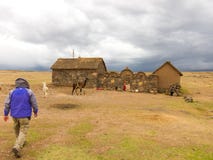 Puno, Peru - December 10, 2011: Man walking towards Small farm near Tombs of Sillustani near Puno, Bolivia royalty free stock image Puno, Peru - December 10, 2011: Man walking towards Small farm near Tombs of Sillustani near Puno, Bolivia royalty free stock image