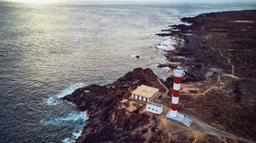 Punta Abona fyr Landskap som förbiser havet Vattnet är skinande arkivbild Punta Abona fyr Landskap som förbiser havet Vattnet är skinande arkivbild