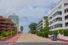 PUNTA DEL ESTE, URUGUAY - 6 MAI 2016 : peu de rue avec les briques rouges sur les promenades latérales, les bâtiments modernes et photos libres de droits PUNTA DEL ESTE, URUGUAY - 6 MAI 2016 : peu de rue avec les briques rouges sur les promenades latérales, les bâtiments modernes et photos libres de droits