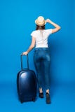 Punto di vista posteriore della donna di camminata con la valigia Bella ragazza nel moto punto di vista della parte del viaggiato fotografia stock libera da diritti Punto di vista posteriore della donna di camminata con la valigia Bella ragazza nel moto punto di vista della parte del viaggiato fotografia stock libera da diritti