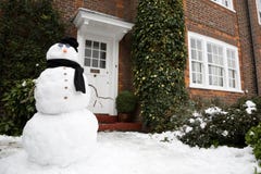Pupazzo di neve e casa fotografia stock libera da diritti Pupazzo di neve e casa fotografia stock libera da diritti