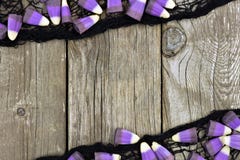 Purper Halloween-suikergoedgraan en zwart doekkader tegen hout Royalty-vrije Stock Afbeeldingen Purper Halloween-suikergoedgraan en zwart doekkader tegen hout Royalty-vrije Stock Afbeeldingen