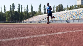 Purposeful Hispanic athlete running at stadium, preparing for marathon, sport stock photography Purposeful Hispanic athlete running at stadium, preparing for marathon, sport stock photography