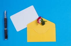 Pusta papierowa karta, koperta z różą i pióro na błękitnym tle, fotografia stock Pusta papierowa karta, koperta z różą i pióro na błękitnym tle, fotografia stock