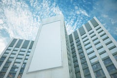 Pusty biały billboard między centrami biznesu przy niebieskiego nieba backg Obrazy Stock Pusty biały billboard między centrami biznesu przy niebieskiego nieba backg Obrazy Stock