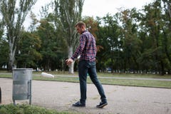 Pusty plastikowa pije butelka śmieci na drogowej podłoga przy zielonym parkiem z plamy zieleni natury tłem obrazy royalty free Pusty plastikowa pije butelka śmieci na drogowej podłoga przy zielonym parkiem z plamy zieleni natury tłem obrazy royalty free