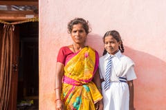 PUTTAPARTHI, ANDHRA PRADESH, INDIA - JULY 9, 2017: Indian woman in sari and girl in school uniform. Copy space for text. Close-up.