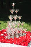 Pyramid of champagne on white table with rose petals stock image Pyramid of champagne on white table with rose petals stock image