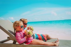 Pys och flicka som dricker kokosnöten på strandsemester royaltyfri foto Pys och flicka som dricker kokosnöten på strandsemester royaltyfri foto