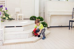 Pysen spelar med leksakbilen hemma arkivbild Pysen spelar med leksakbilen hemma arkivbild