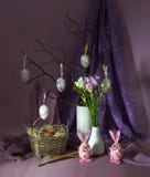 Påsksammansättning med ägg i en vide- korg, kyrka undersöker, fattar i en vas och blommar freesia arkivfoto Påsksammansättning med ägg i en vide- korg, kyrka undersöker, fattar i en vas och blommar freesia arkivfoto